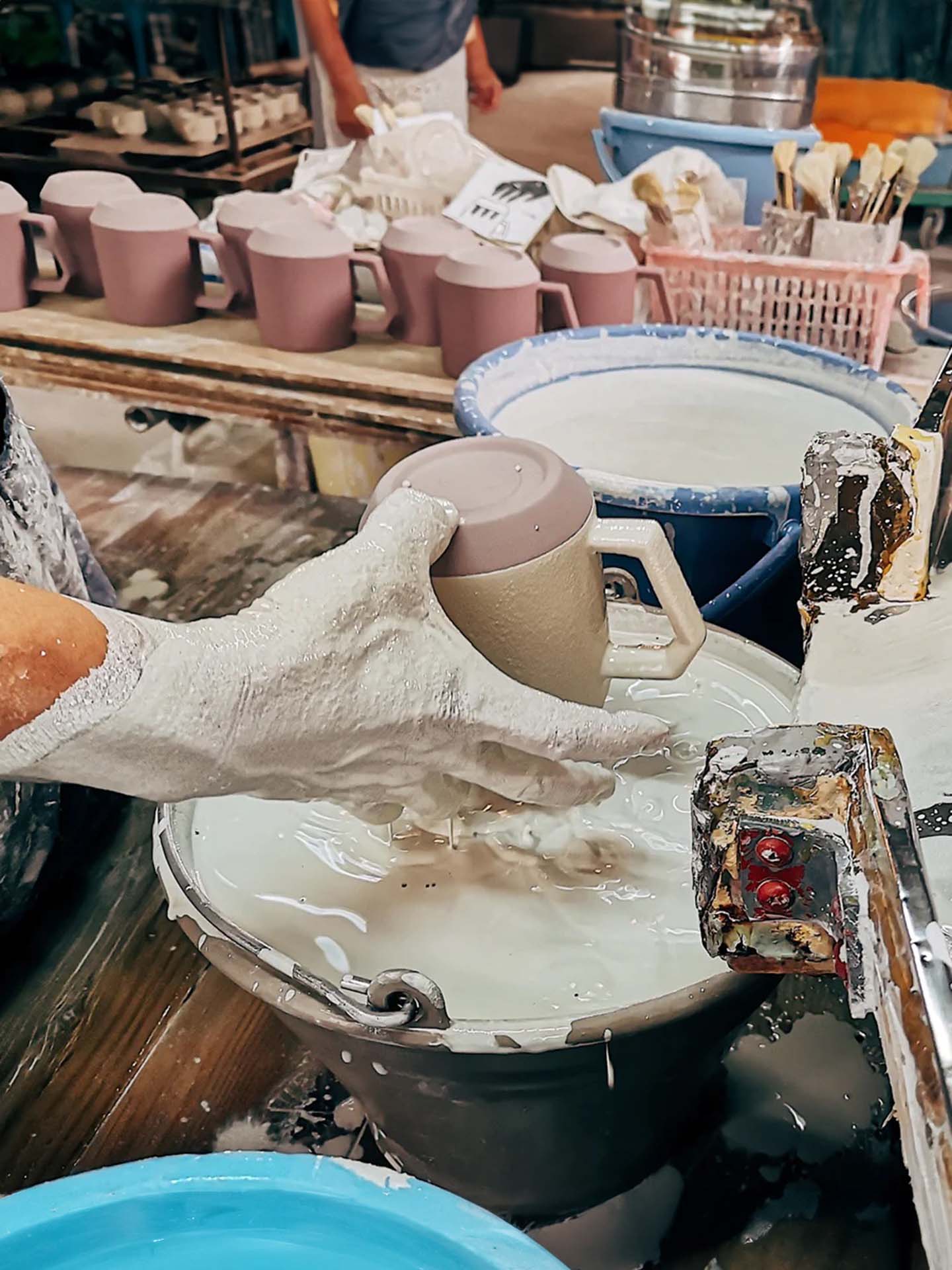 A person holding a mug in a bucket.