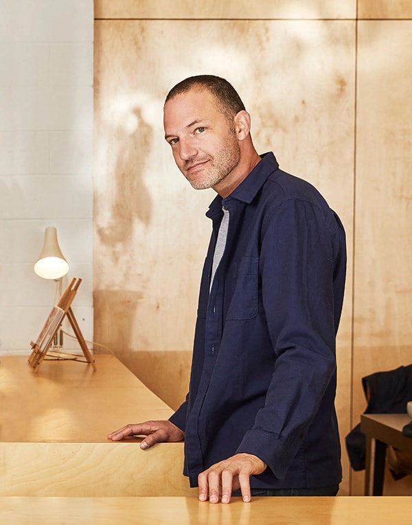 A man standing in front of a wooden counter.
