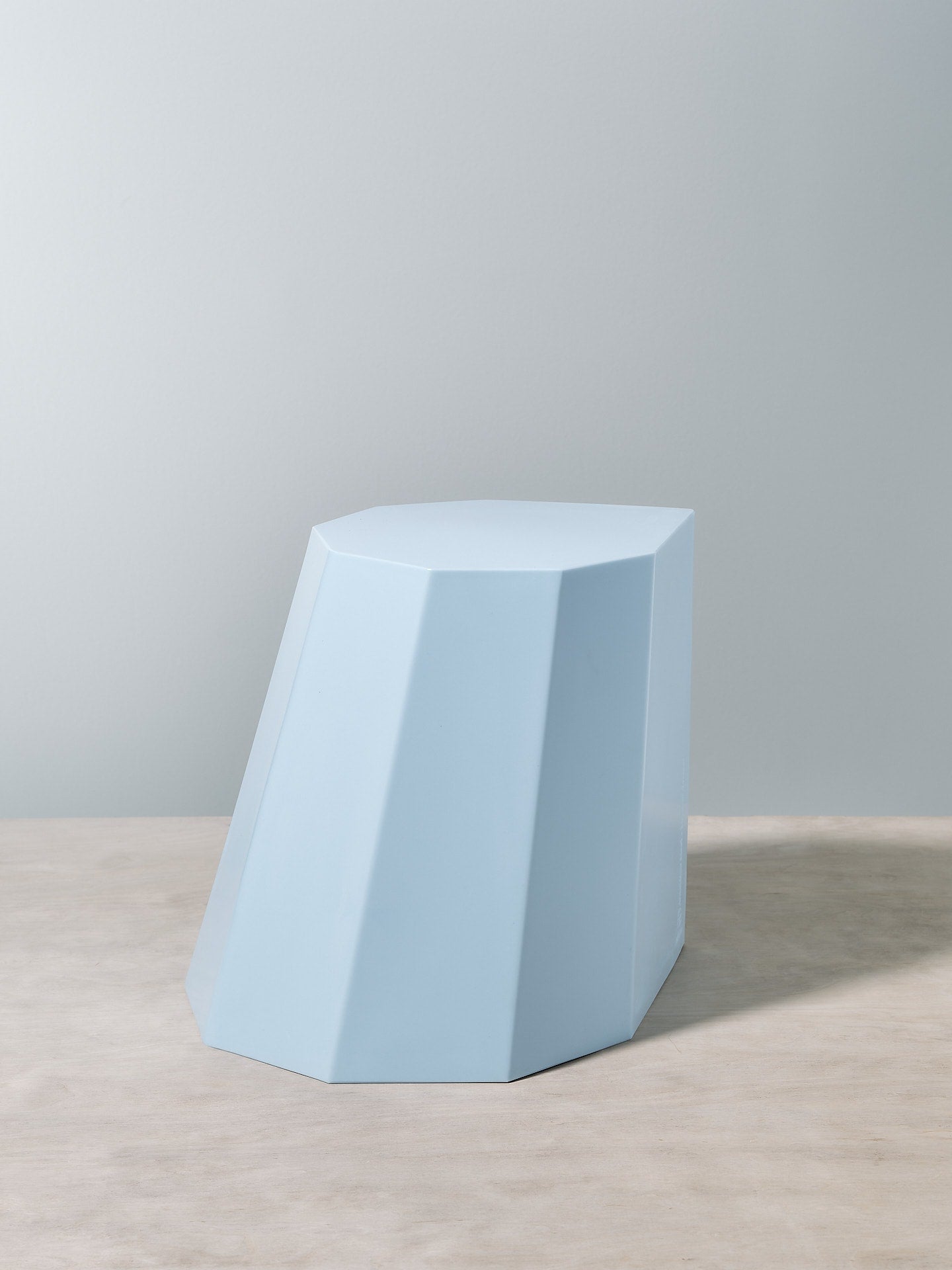 A Martino Gamper Arnoldino Stool - Baby Blue on top of a wooden table.