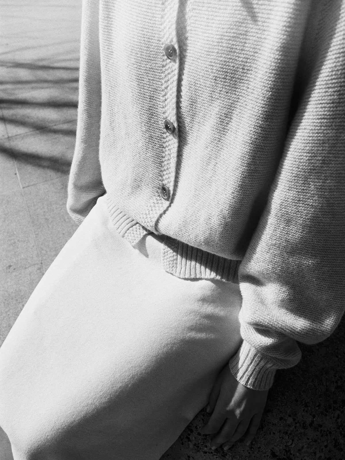 A person wearing a white skirt and an Italian air-spun merino wool Loft Cardigan in an oversized design by Francie.