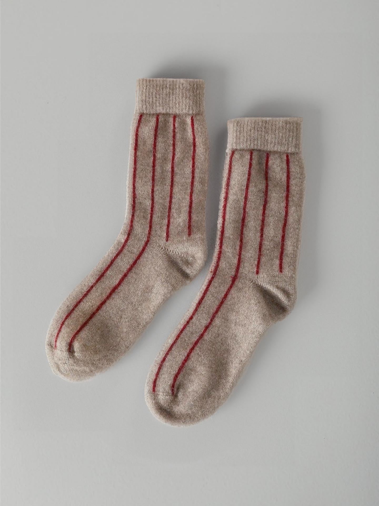 A pair of Francie Possum Merino Socks – Natural & Poppy Stripe displayed on a light gray background.