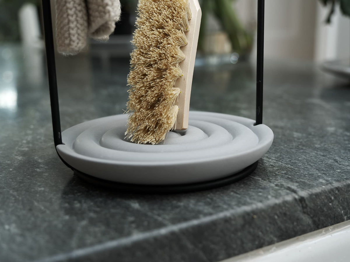 An Iris Hantverk dish brush holder on a counter top.