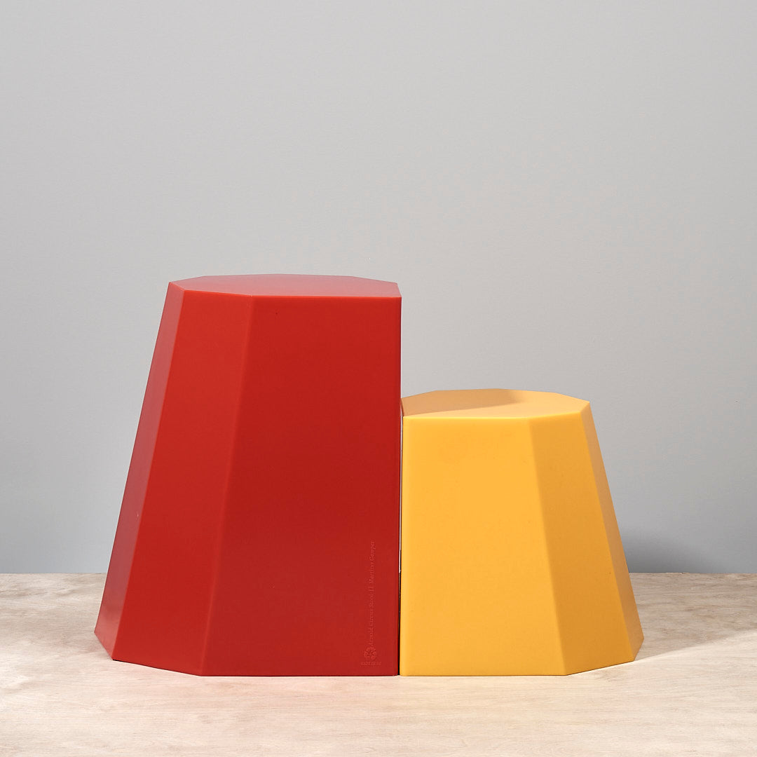 A pair of Arnoldino Stools – Yellow by Martino Gamper on a table.