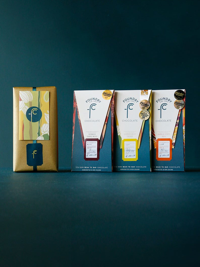 Foundry Chocolate&#39;s Three Origin Gift Pack – Gold Winners packaging showcased on a dark background.