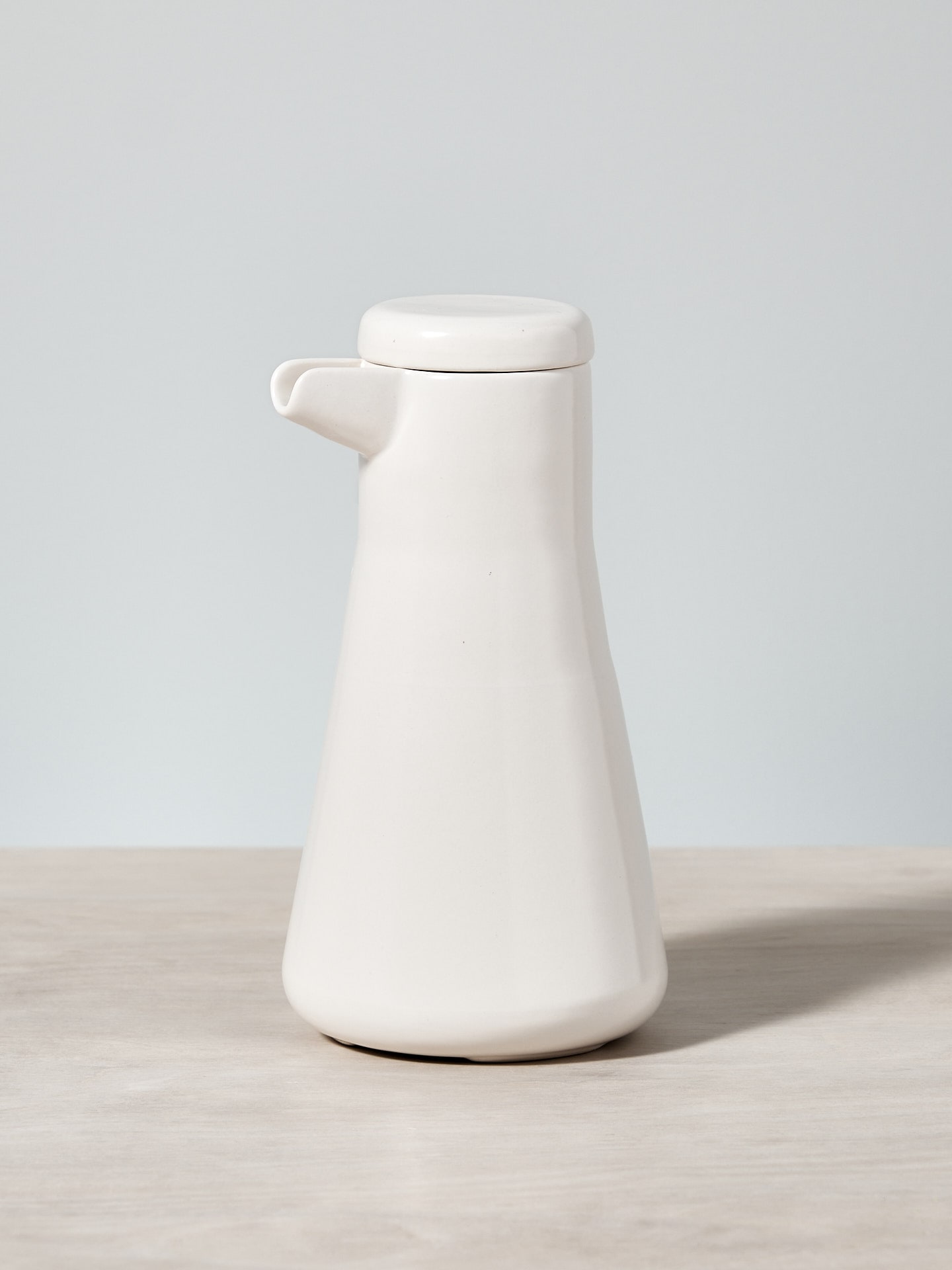 A Large Twin Wall Coffee/Tea Pot - Satin White by Gidon Bing sitting on a wooden table.