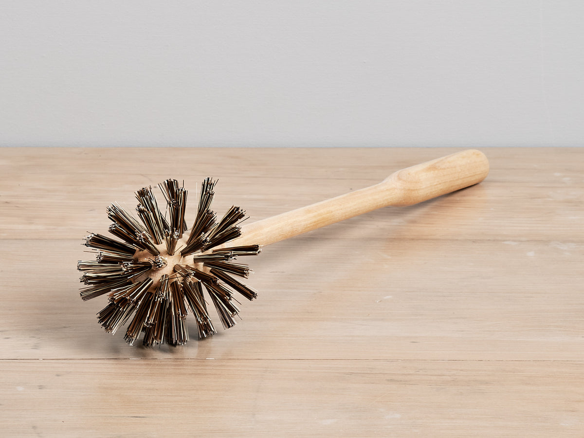 An Iris Hantverk toilet brush – replacement on top of a wooden table.