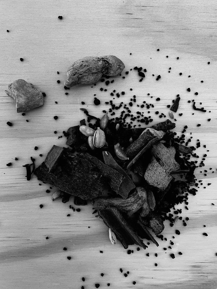 A black and white photo of a pile of Home Chai spices on a table by Kaputi Studio.