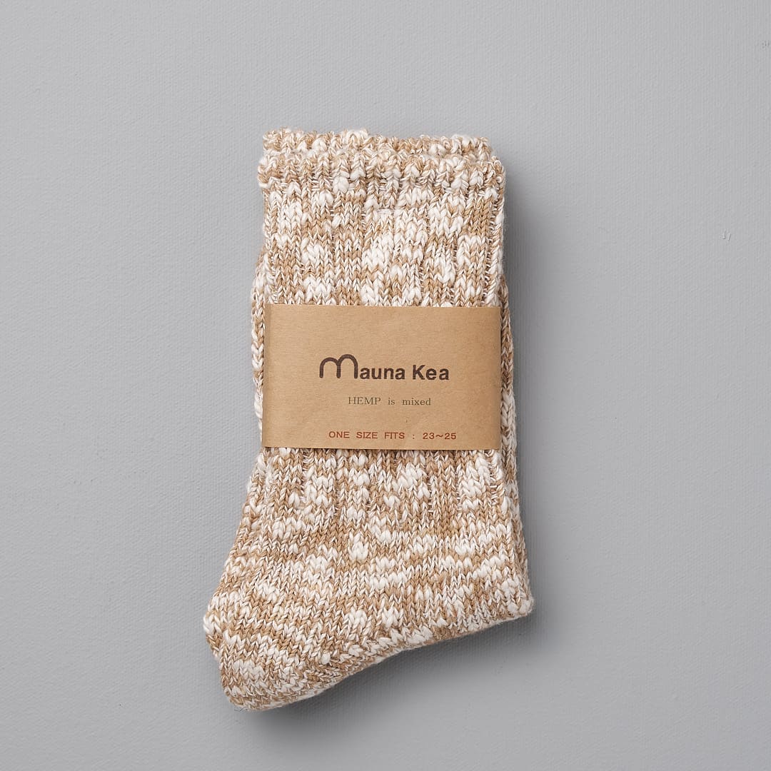 A pair of Japanese Slub Socks – Beige by Mauna Kea with a label.