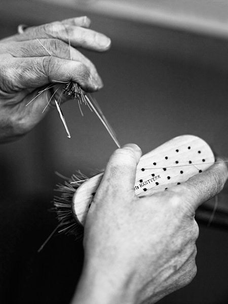 Black and white photo of a person working on an Iris Hantverk Vegetable Brush.