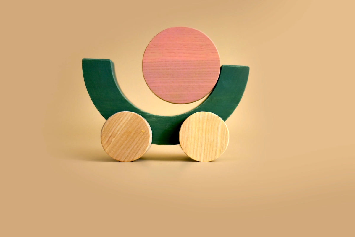 A MinMin Copenhagen Balancing Car with a pink and green egg on it.