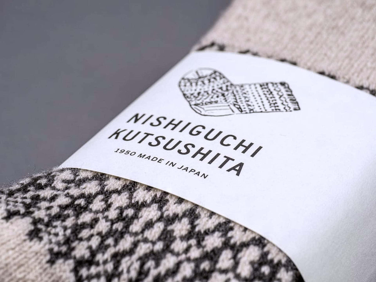 A sock with a label that says Oslo Wool Jacquard Socks – Oatmeal from Nishiguchi Kutsushita.