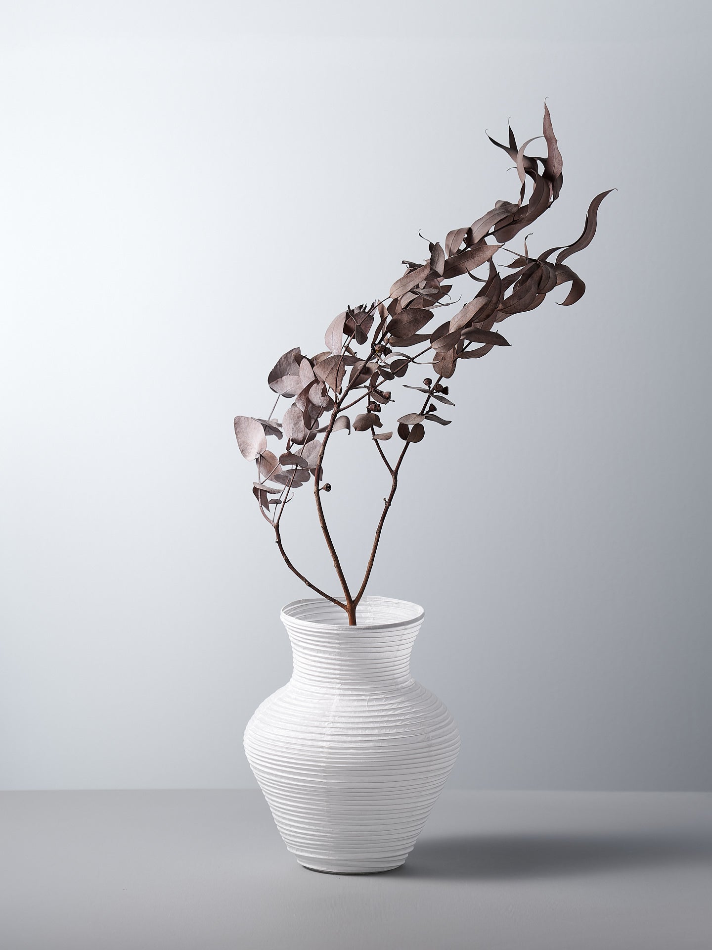 A Nobi-tsutsu Paper Vase - №2 by Hayashi Kougei with a plant in it.