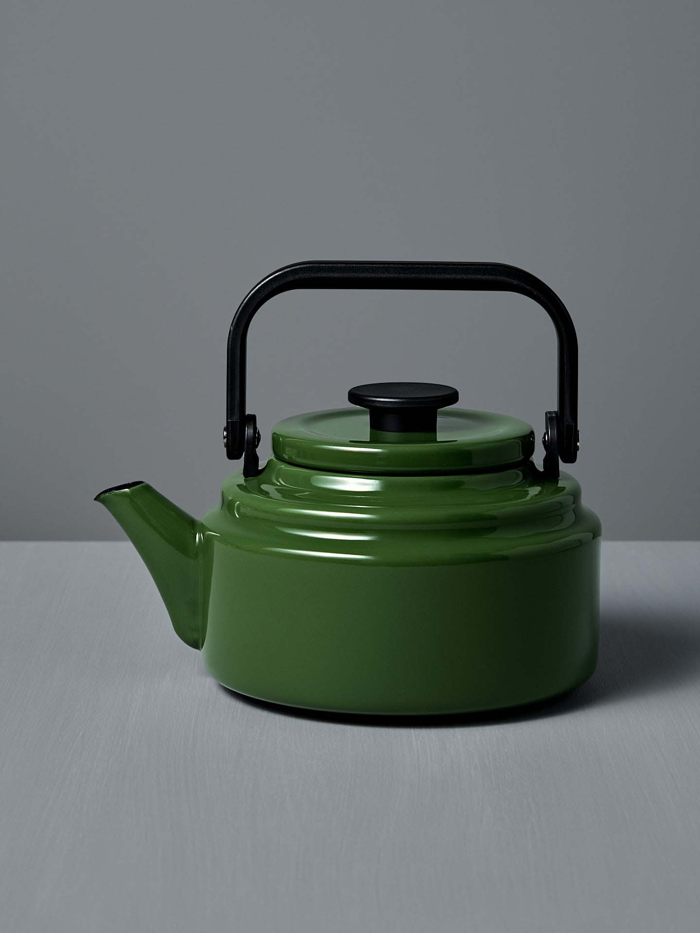 An Amu Stove-top Kettle - Green by Noda Horo on a grey background.