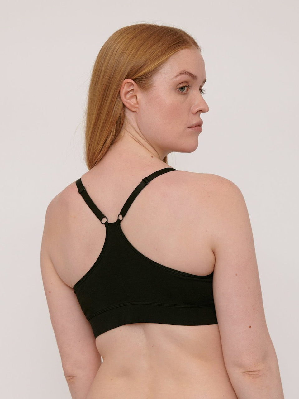 The back view of a woman wearing an Organic Basics Basic Bra ⋅ organic cotton – Black.