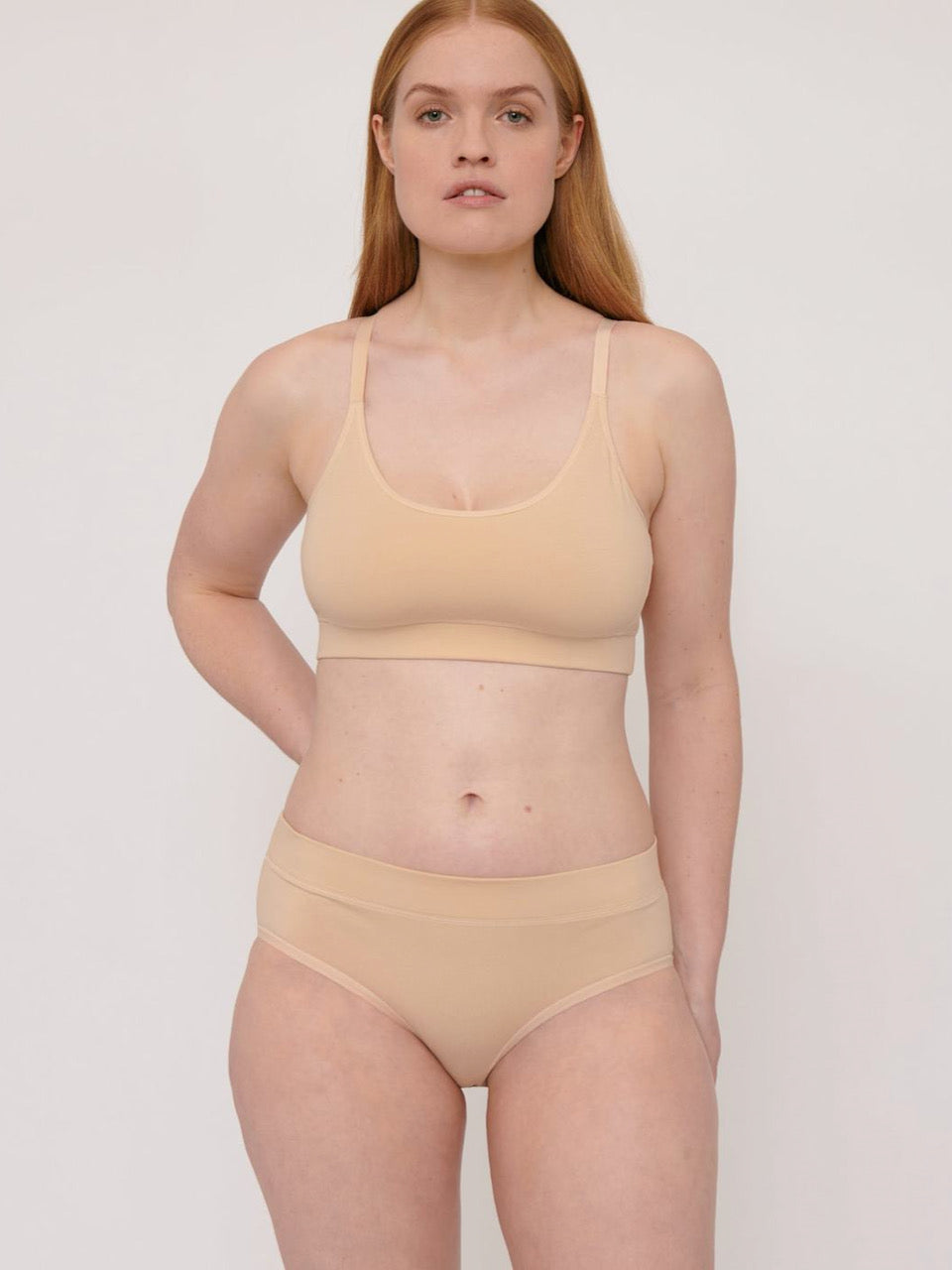 A woman in Organic Basics Organic Cotton Bikini Briefs (2-pack) – Oak.
