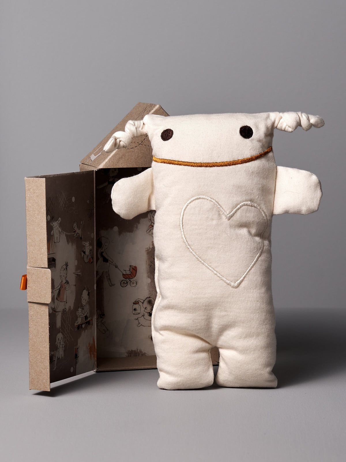 A white Monsieur Tsé-Tsé Classic stuffed animal made by Raplapla is sitting in a box.