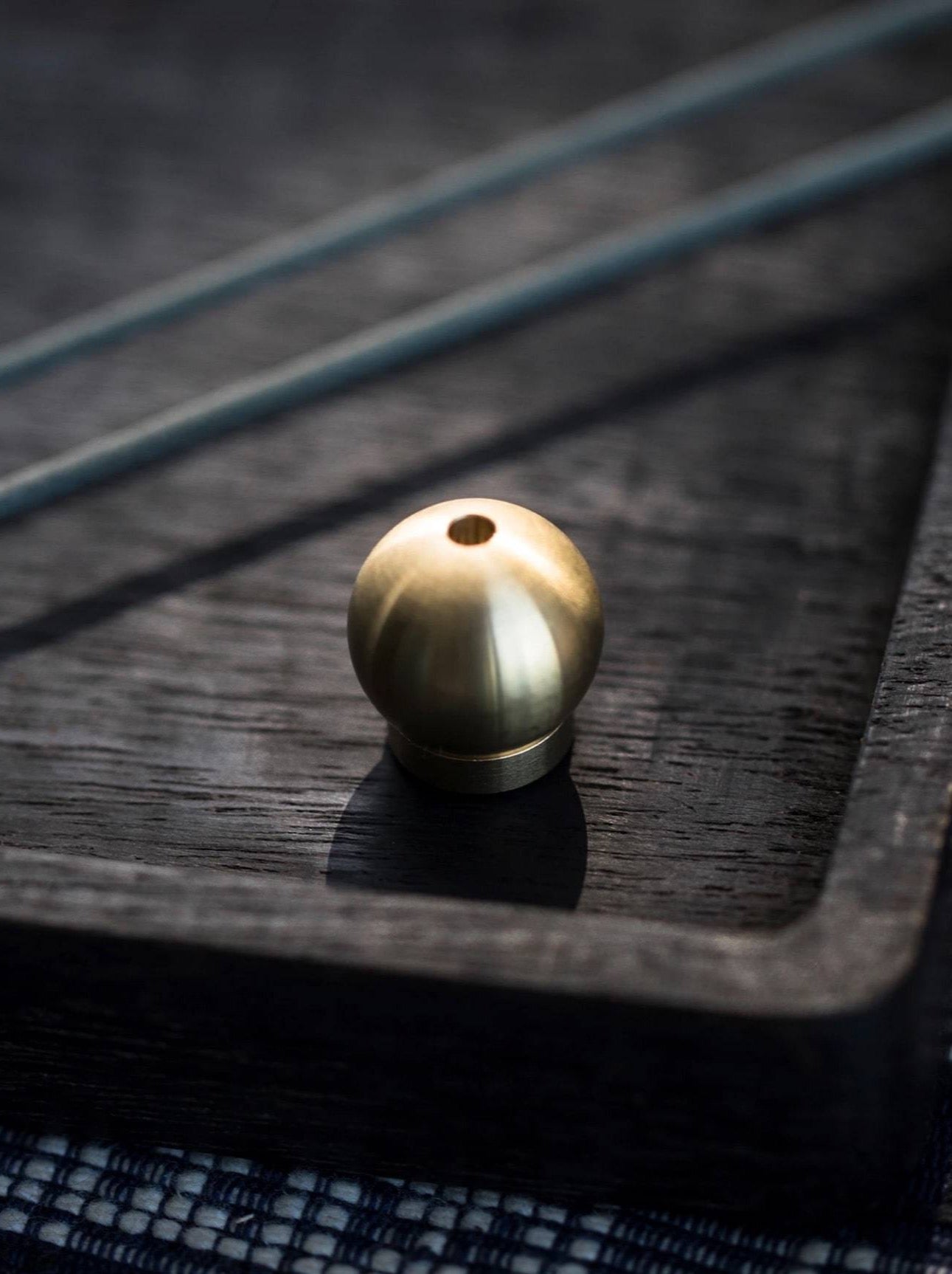 A small Senko Brass Ball Incense Holder sits on top of a black tray.