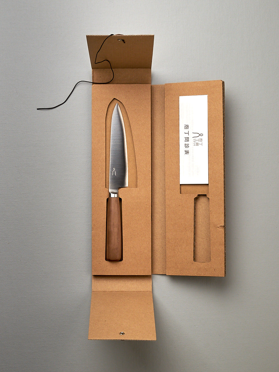 A Tadafusa Hocho Petty Knife in a cardboard box with a label on it.