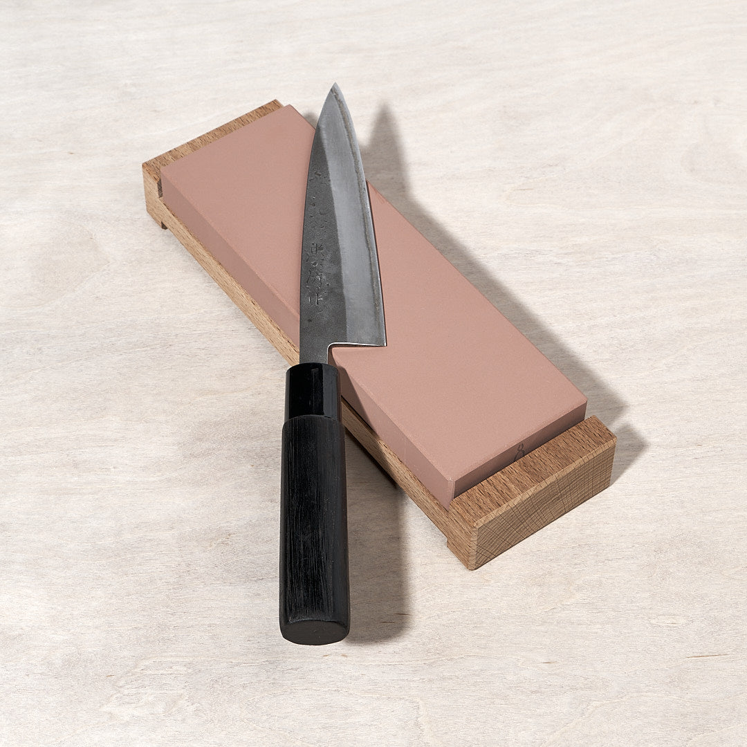 A Tadafusa knife on top of a Whetstone – #800 grit wooden block.