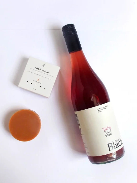 A bottle of Rosé Wine Soap next to a piece of chocolate. (Brand: Studio Star)