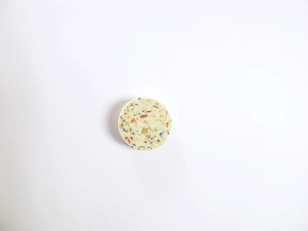 A small white Terrazzo Soap button with a lot of speckles on it by Studio Star.