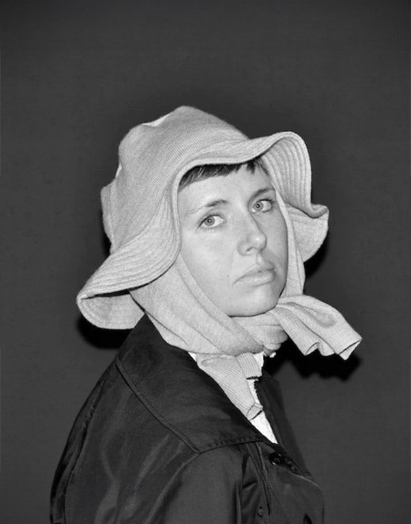 A black and white photo of a woman wearing a hat.