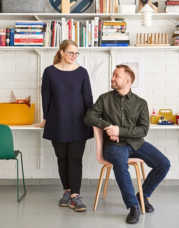 A man and woman standing in front of a bookshelf.