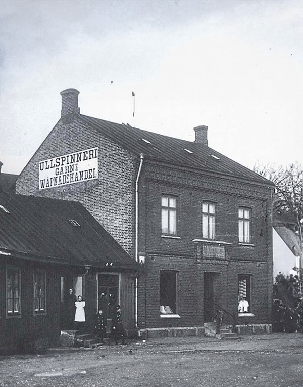 A black and white photo of a building with a sign on it.