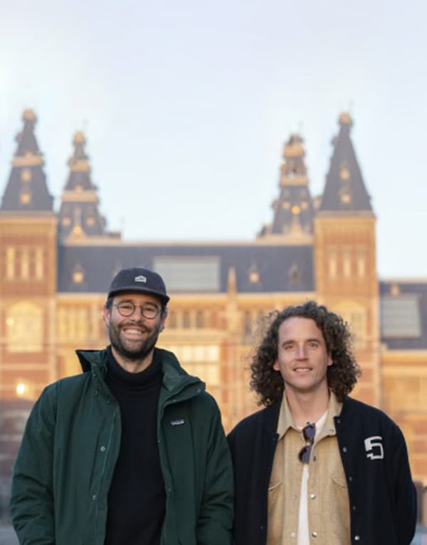 Two men standing in front of a large building.