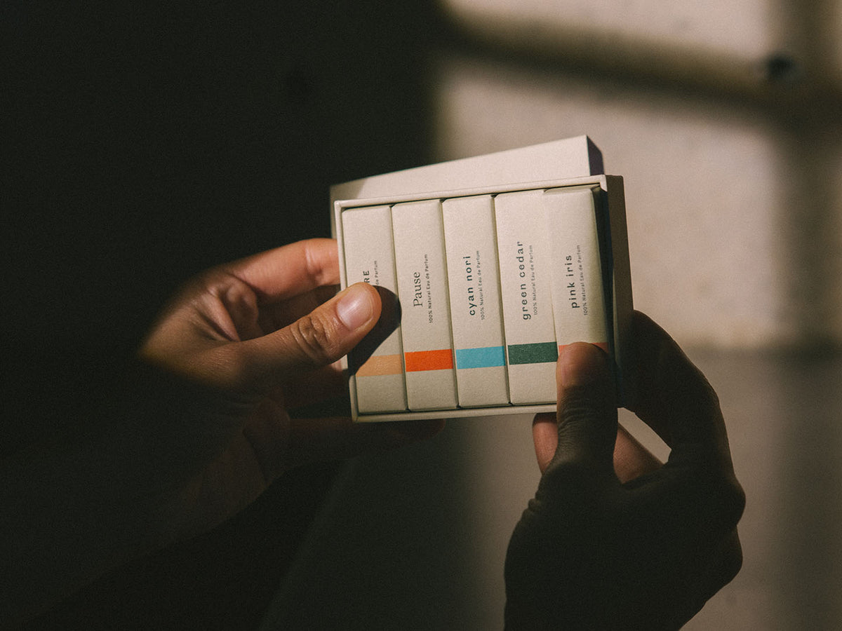 A person holding up a presentation box of the Abel Discovery Set – 5 most popular scents, all made with 100% natural ingredients.