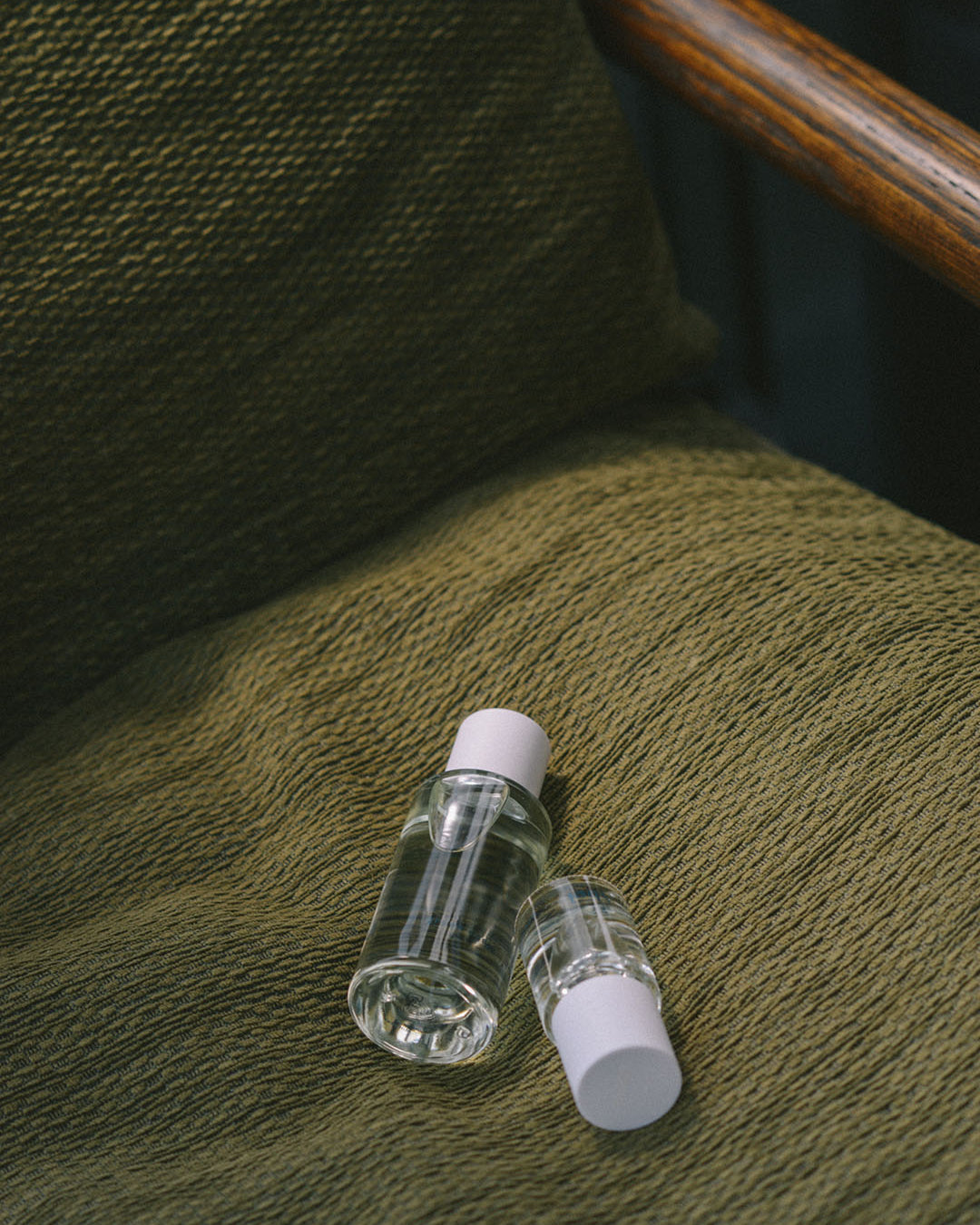 A bottle of Green Cedar – velvety, rich wood essential oil by Abel on a chair.