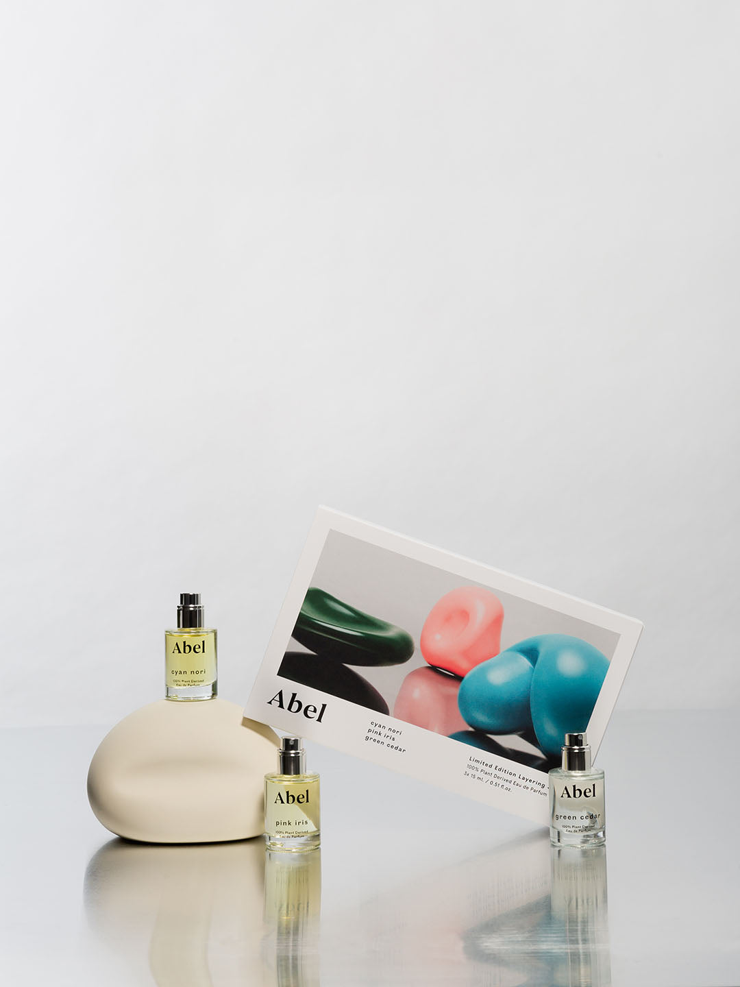 Assorted Abel Layering Set – Cyan Nori ⋄ Green Cedar ⋄ Pink Iris eau de parfum products displayed with a promotional card on a minimalist background.