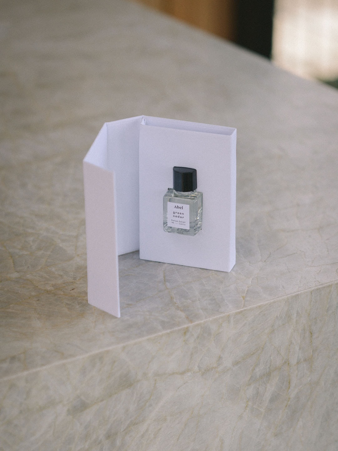 A small bottle of Abel&#39;s Green Cedar Parfum Extrait – for vitality, emitting a captivating scent and labeled as a natural parfum extrait, sitting on a table.