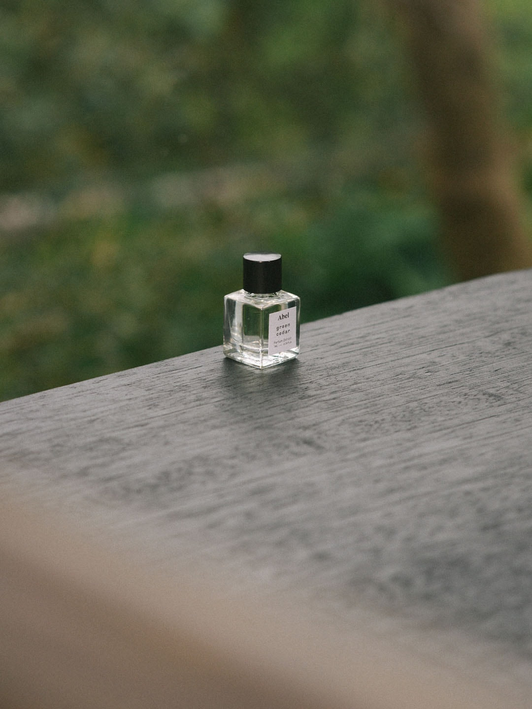 A small bottle of Abel&#39;s Green Cedar Parfum Extrait – for vitality sitting on top of a table, emitting a captivating scent.
