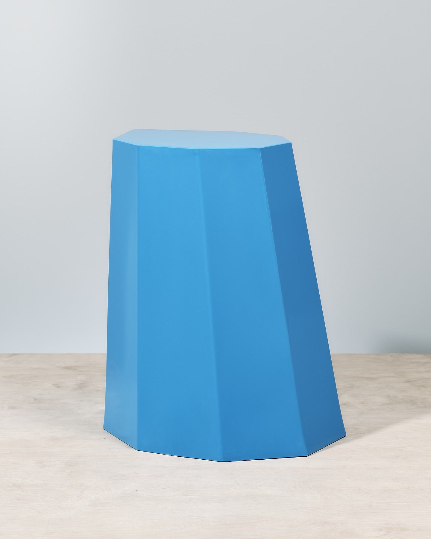 An Arnold Circus Stool – Boat Blue sitting on top of a wooden table. (Martino Gamper)