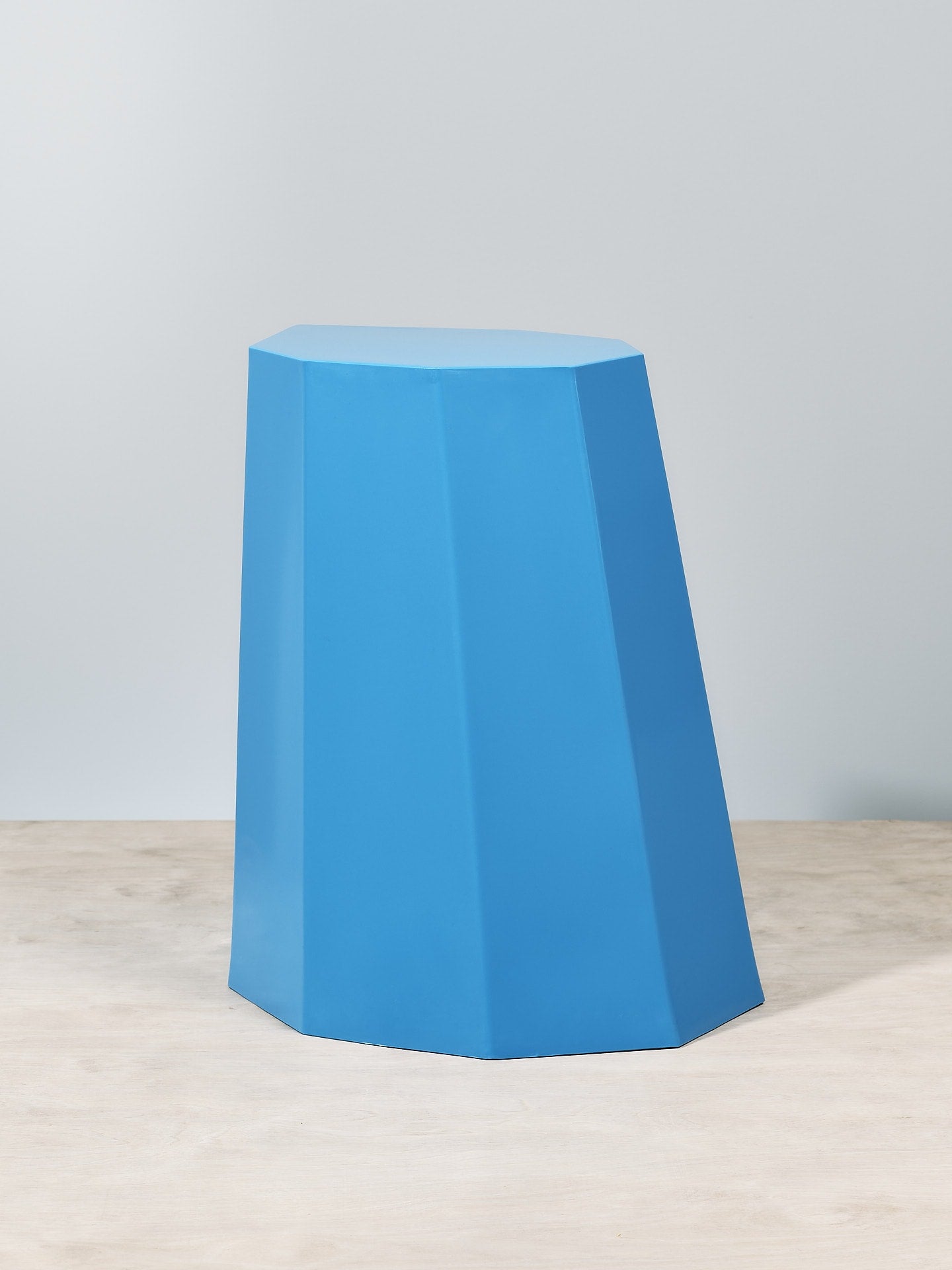 An Arnold Circus Stool – Boat Blue sitting on top of a wooden table. (Martino Gamper)