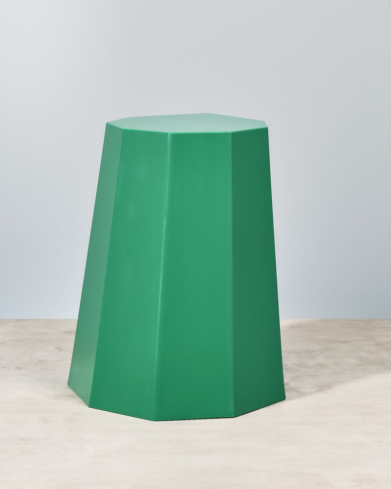 A Martino Gamper Arnold Circus Stool - Bright Green on top of a wooden floor.