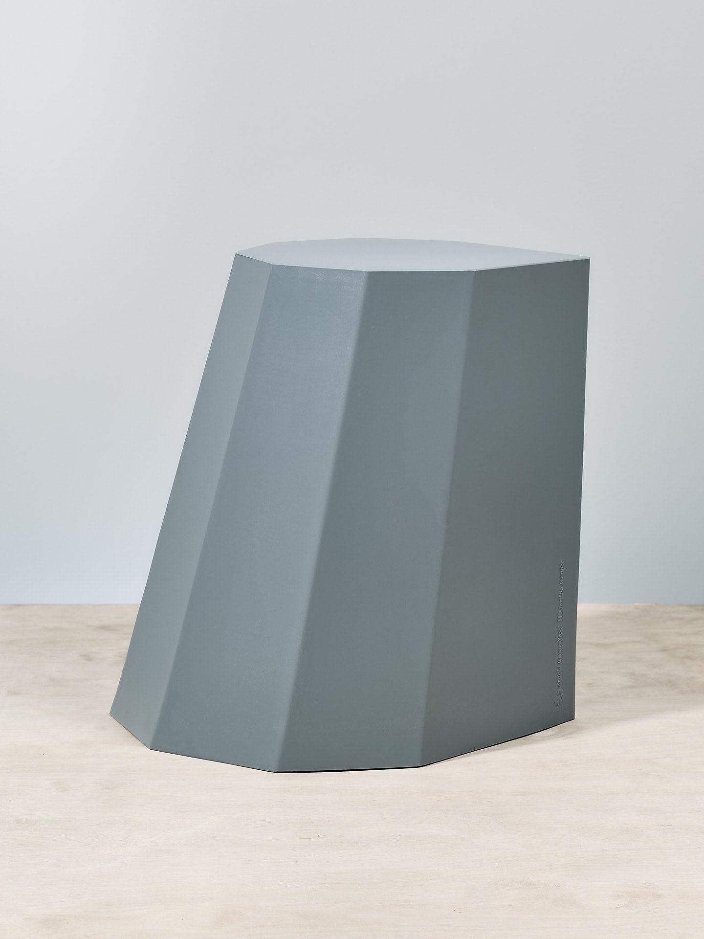 An Arnold Circus Stool - French Grey sitting on top of a wooden floor.