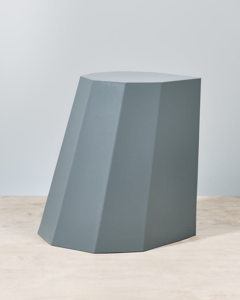 An Arnold Circus Stool - French Grey sitting on top of a wooden floor.