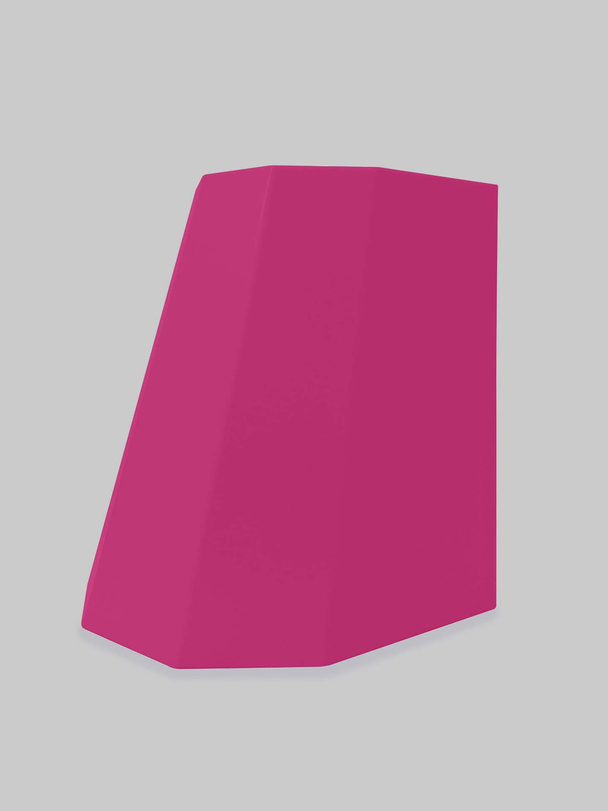 A magenta geometric object, the Arnold Circus Stool by Martino Gamper, with a slanted rectangular shape crafted from recyclable polyethylene, stands against a light gray background.