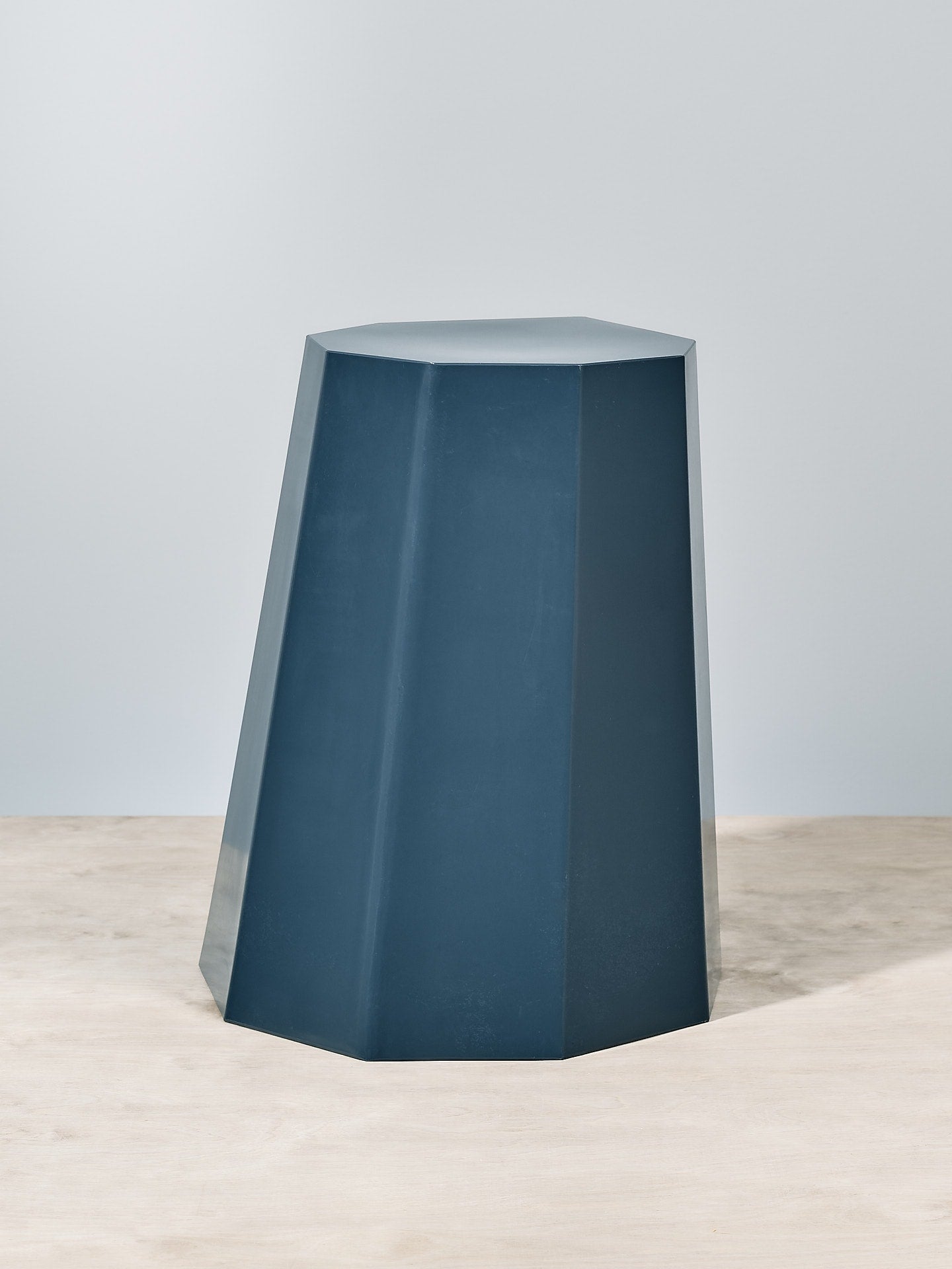 A Martino Gamper Arnold Circus Stool - Navy on a wooden floor.