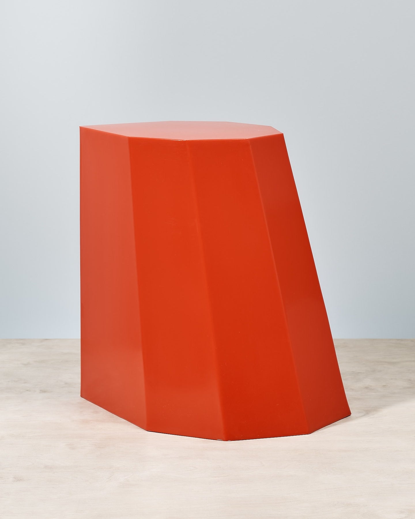 An Arnold Circus Stool - Red by Martino Gamper on a wooden floor.