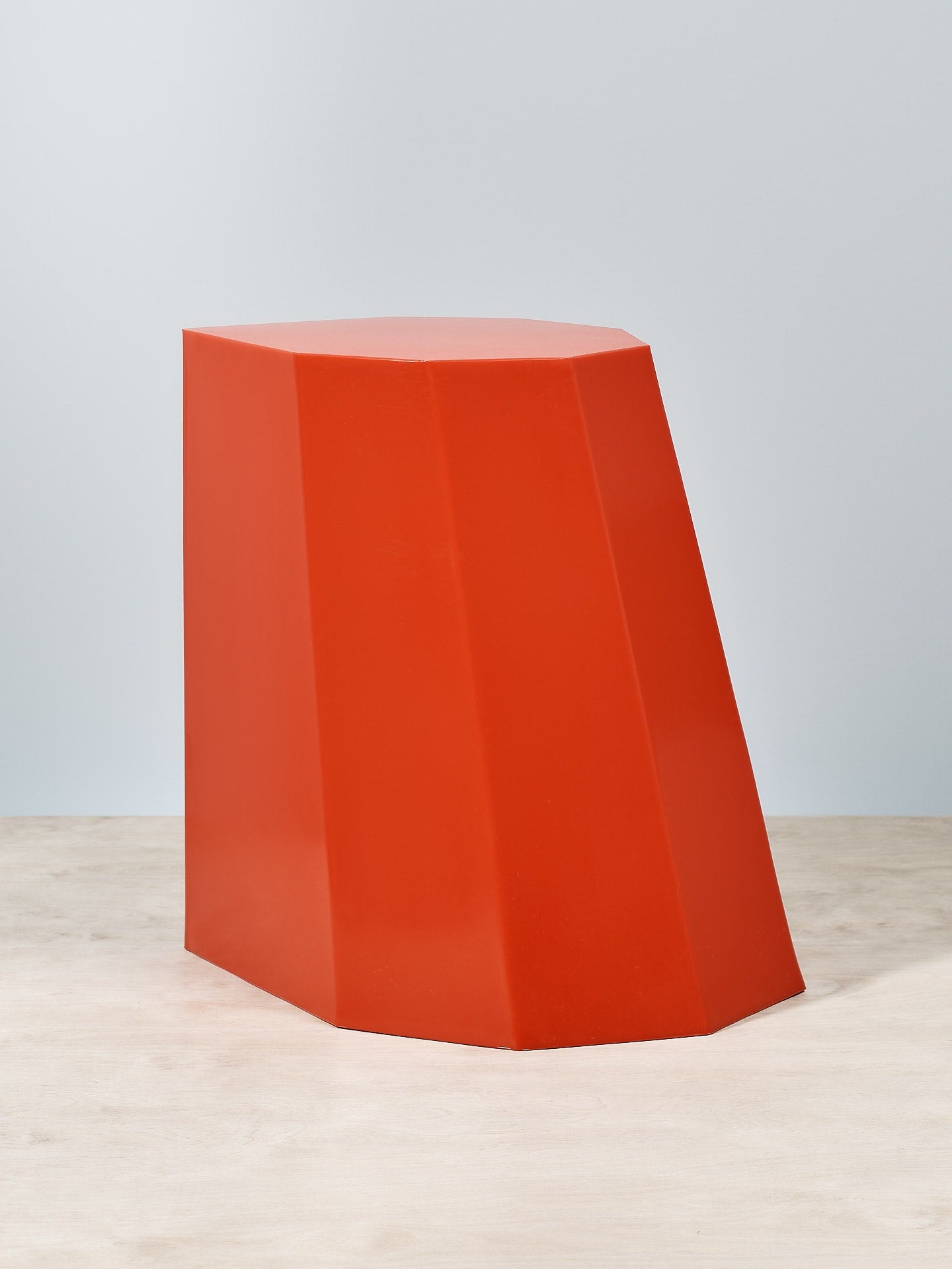 An Arnold Circus Stool - Red by Martino Gamper on a wooden floor.