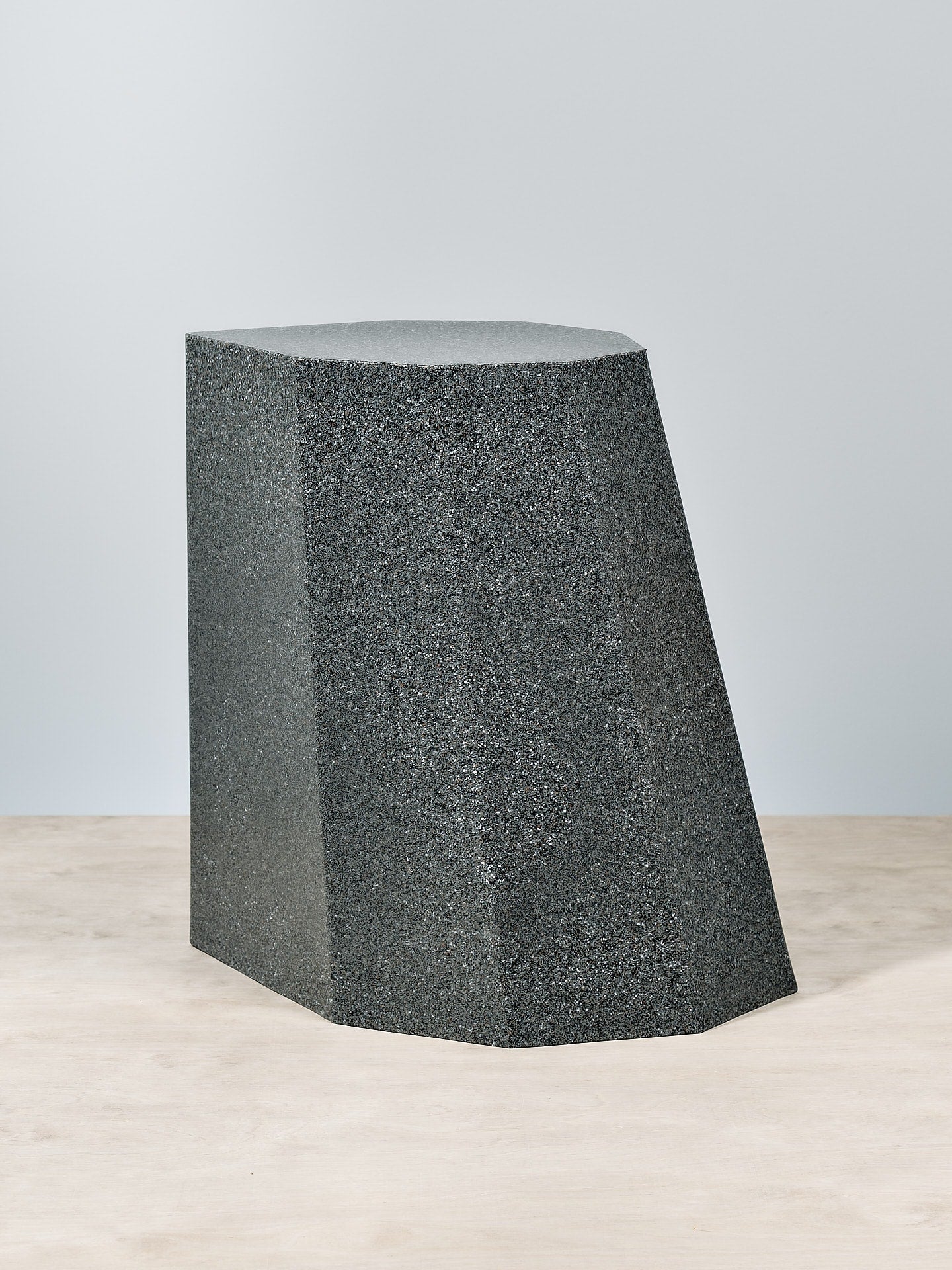 A Martino Gamper Arnold Circus Stool – Speckle Grey on a wooden floor.