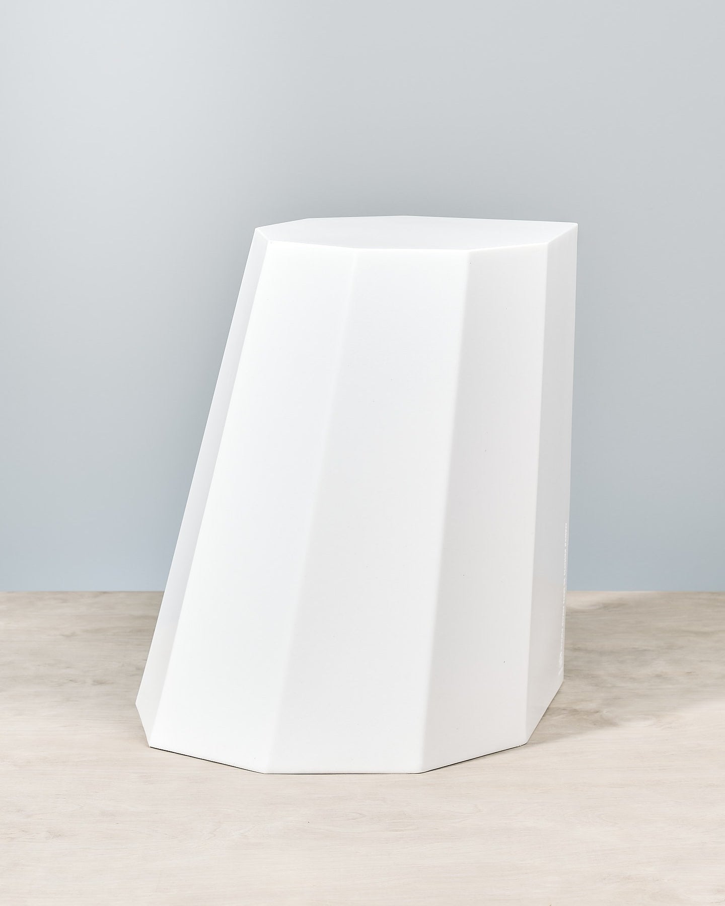 An Arnold Circus Stool - Chalk by Martino Gamper sitting on top of a wooden table.