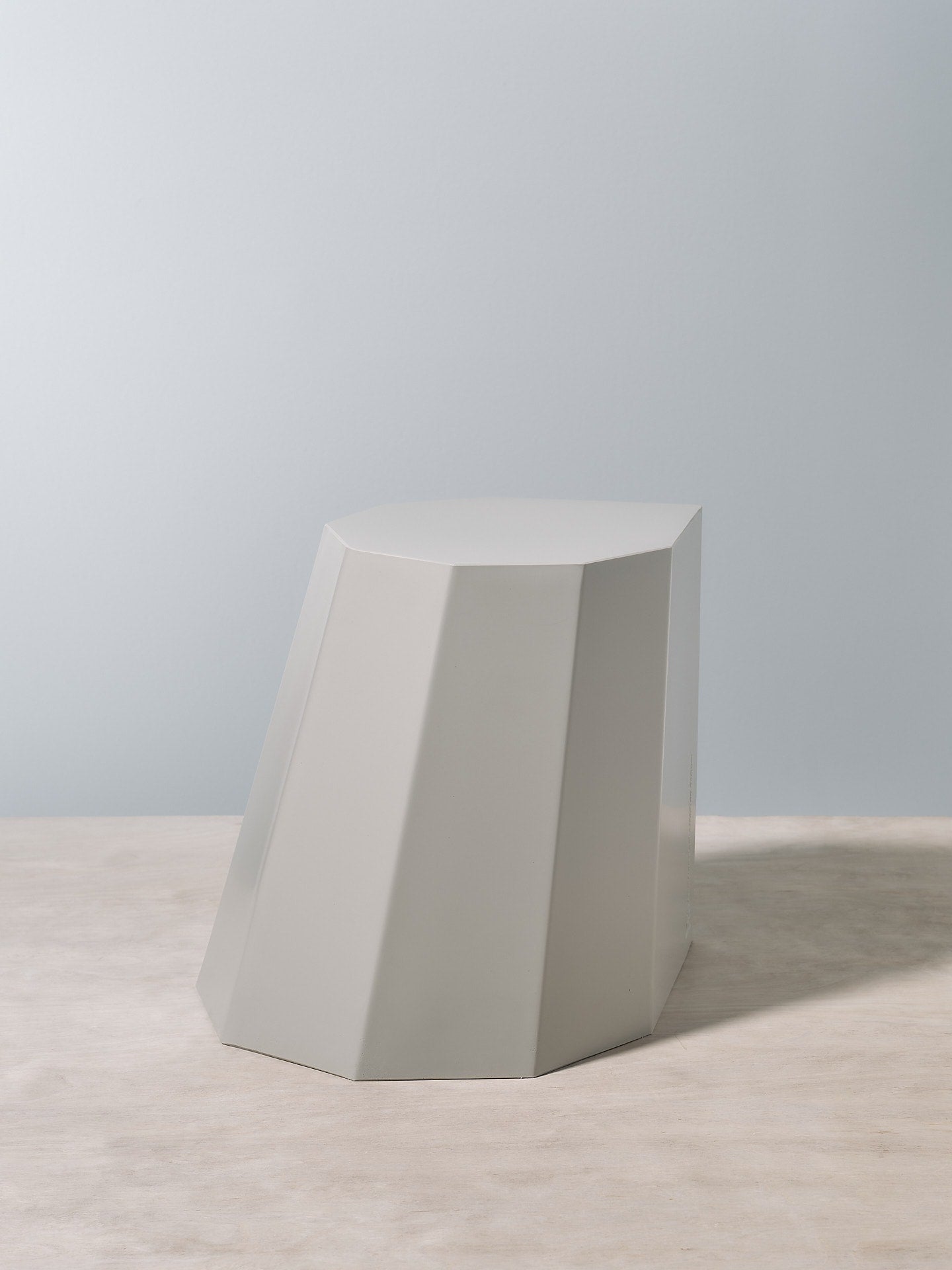 A Arnoldino Stool - Cloud by Martino Gamper on top of a wooden table.