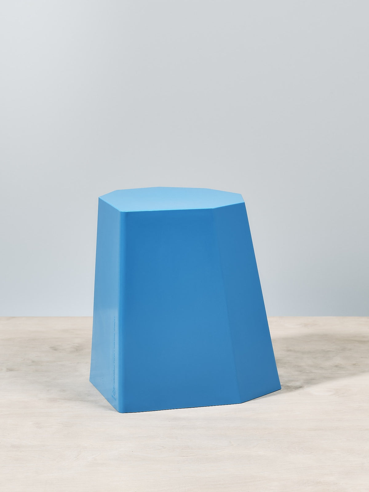 An Arnoldino Stool – Boat Blue sitting on top of a wooden table. (Brand: Martino Gamper)