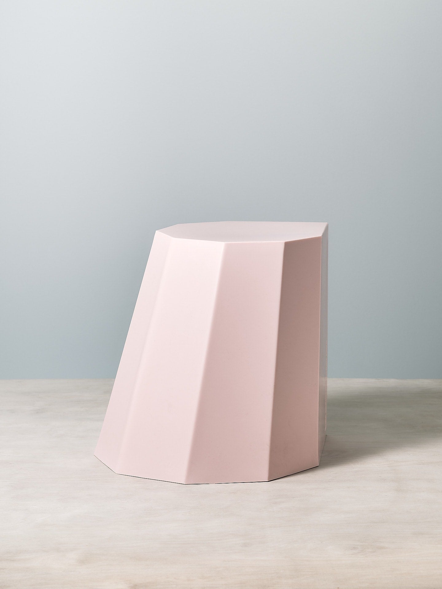 An Arnoldino Stool – Pink by Martino Gamper sitting on top of a table.