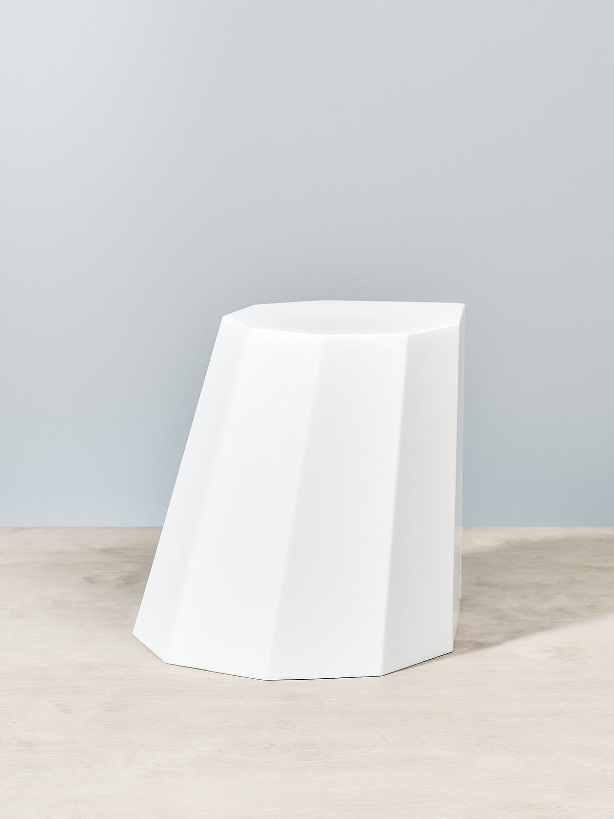 An Arnoldino Stool – Chalk by Martino Gamper on a wooden table.