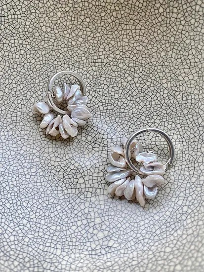 A pair of Coral Sleepers earrings by Avara Studio on a plate.